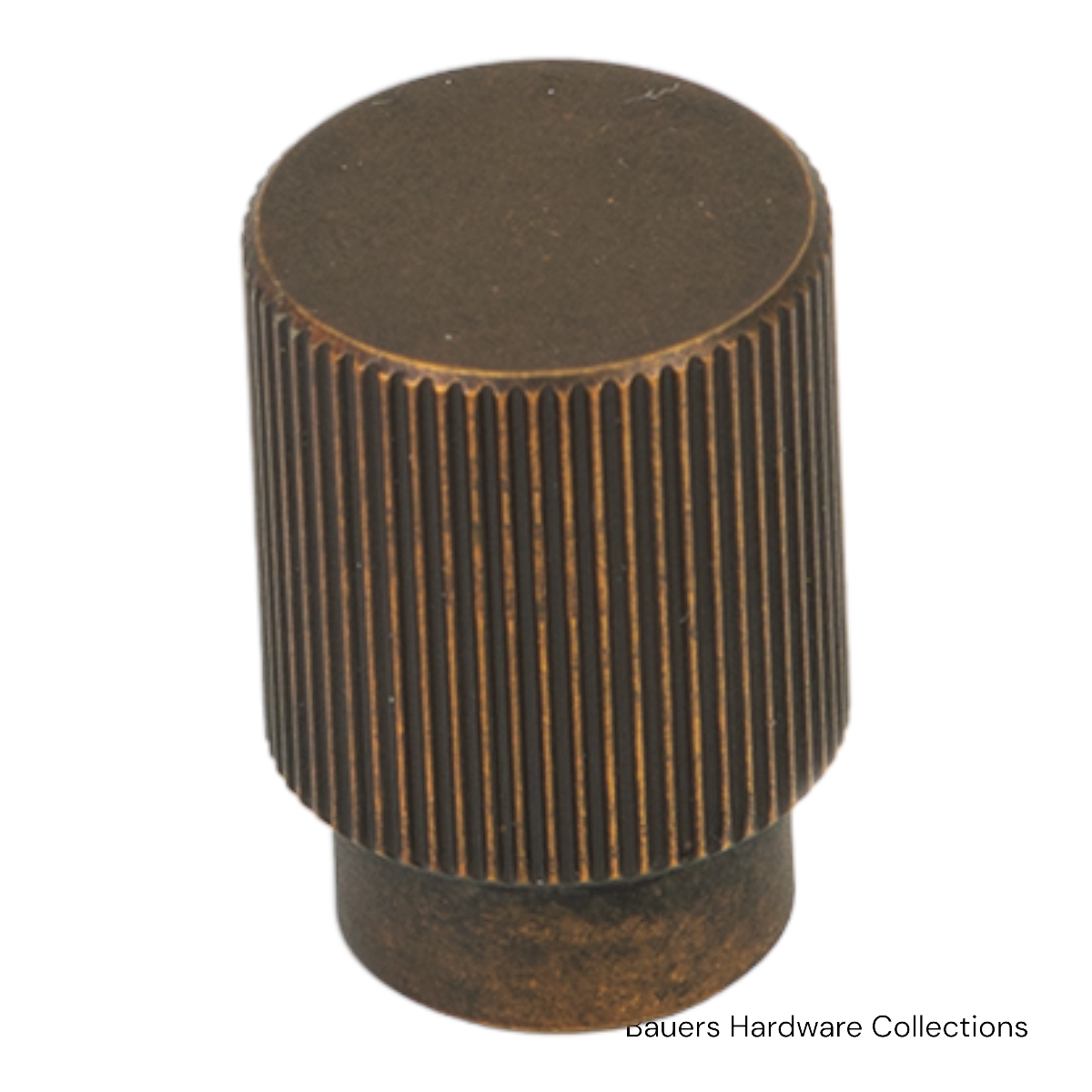 Classic round Charlotte cabinet knob in antique brass finish installed on a kitchen cabinet door